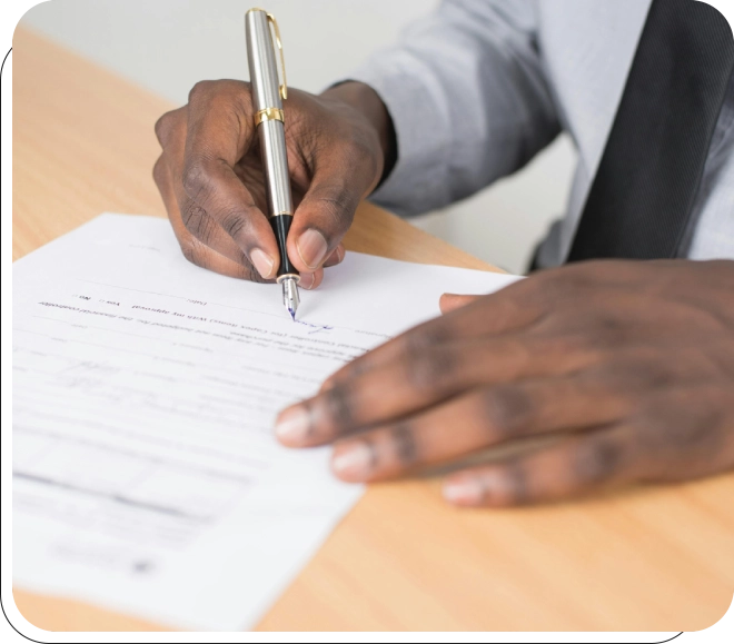 A person writing on paper with a pen.